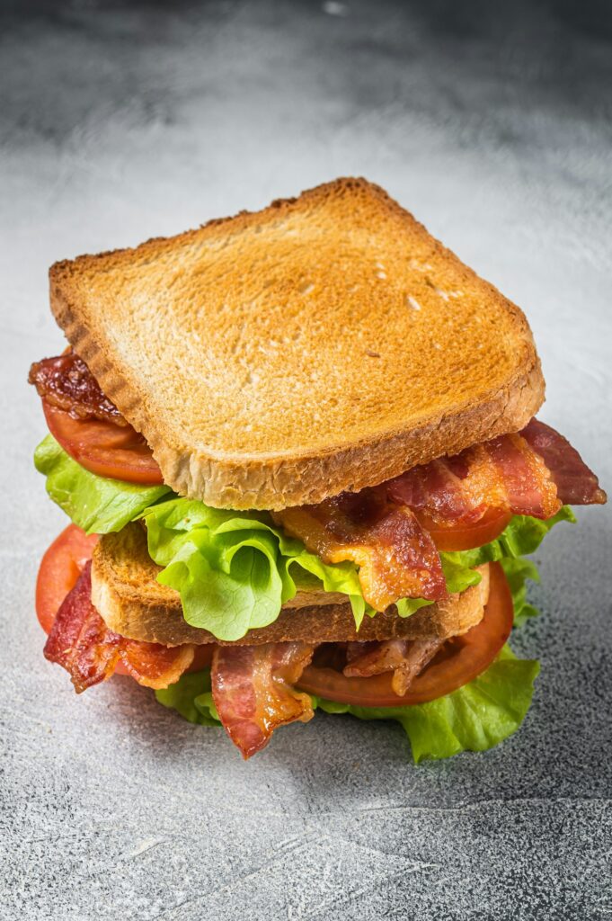 BLT toasted sandwich with bacon, tomato and lettuce. Gray background. Top view